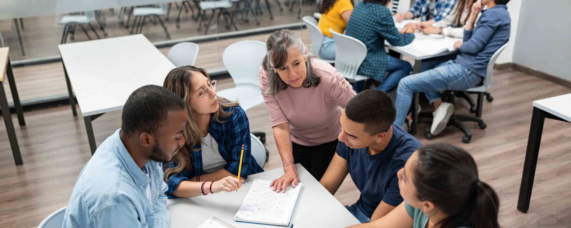 An image of educators working together around a table, in collaboration.