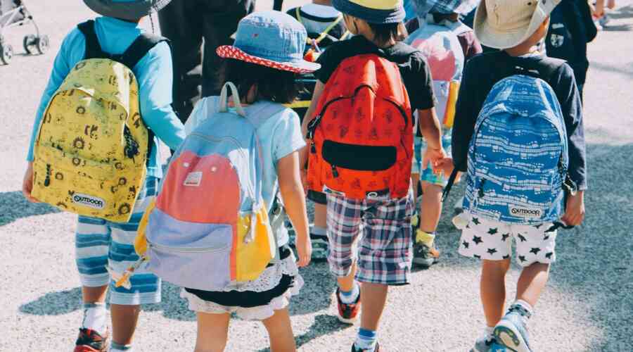 A group of young students with backpacks enter school