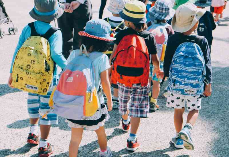 A group of young students with backpacks enter school