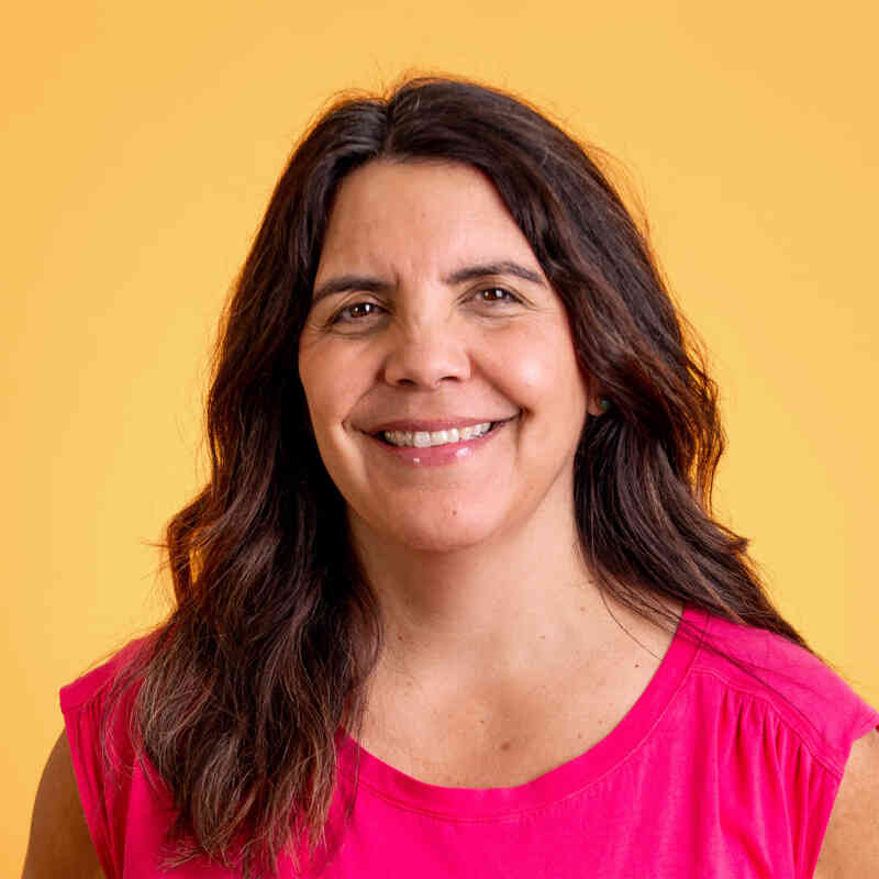 A headshot of Ali Metzler against a bright yellow backdrop.
