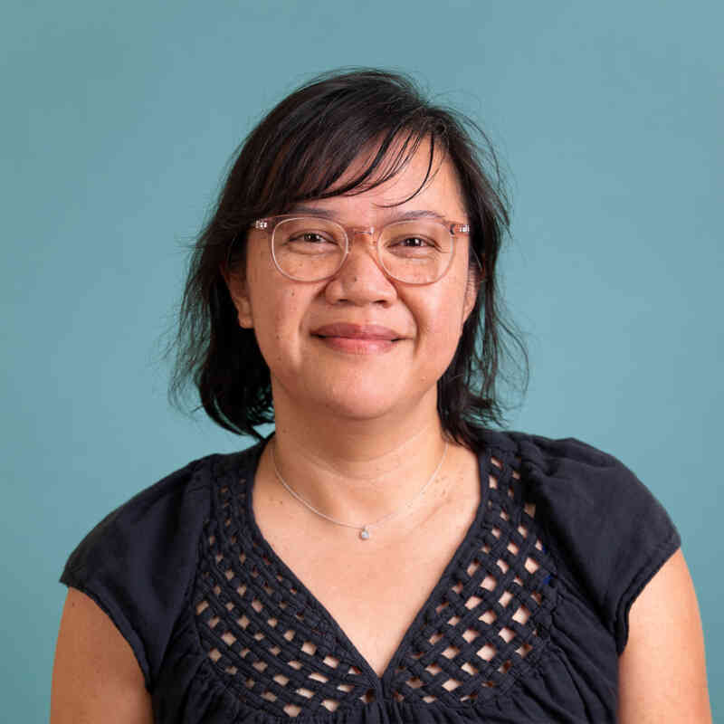 A headshot of Jora Atienza Washington against a teal backdrop.