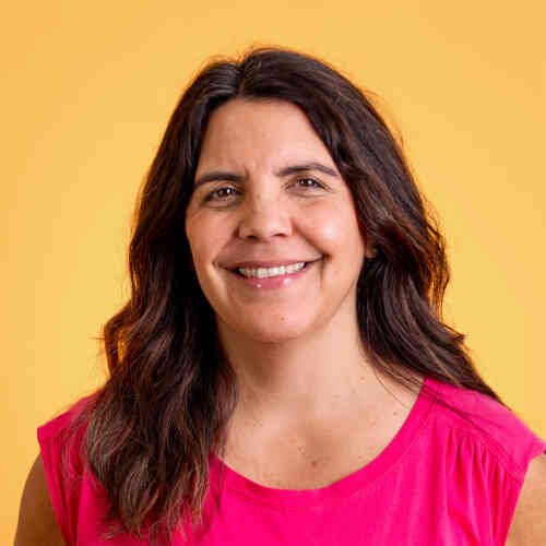 A headshot of Ali Metzler against a bright yellow backdrop.